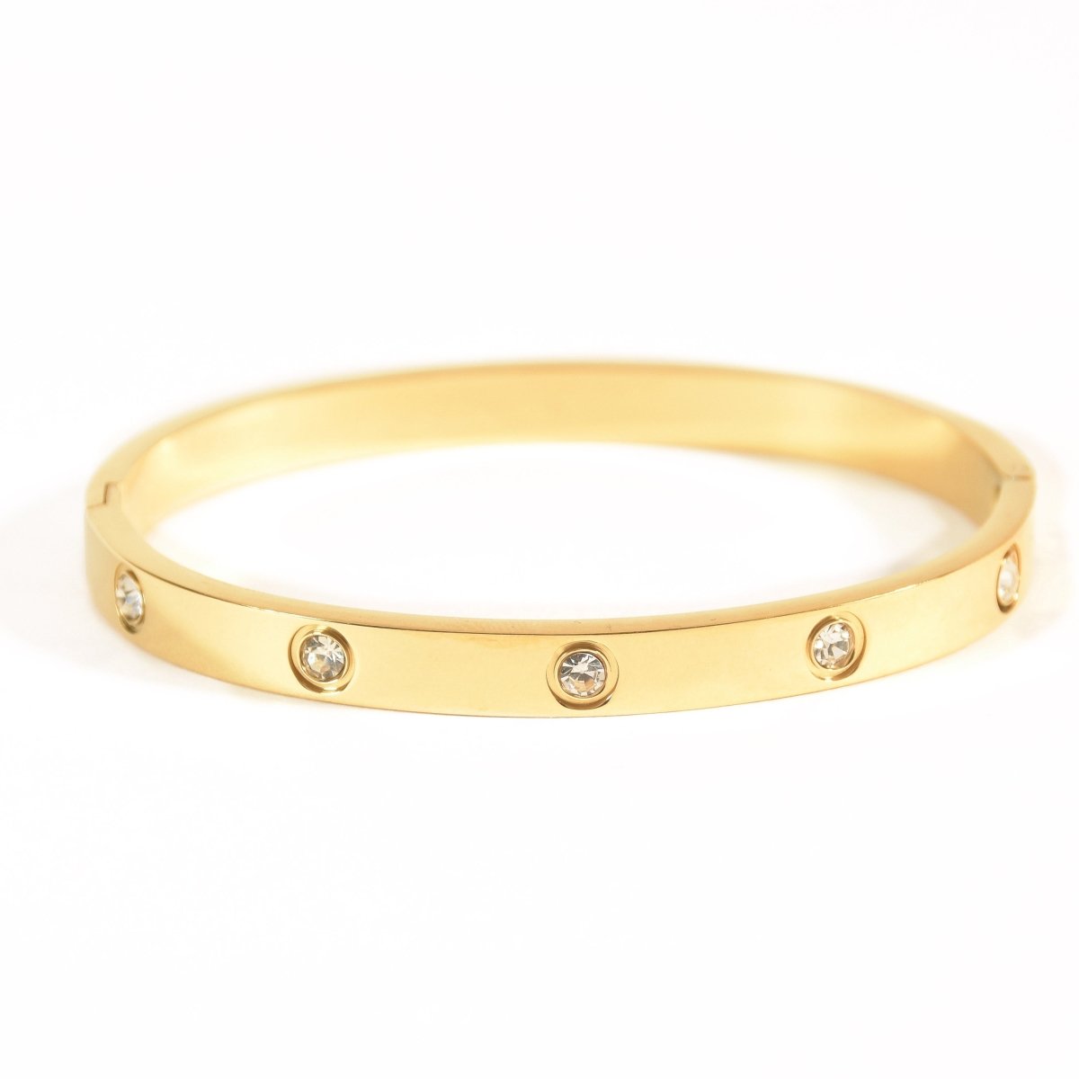Elegant stainless steel bangle with a sleek push-lock design and polished finish, available in gold, rose gold, and silver, perfect for everyday wear, effortless stacking, and styling with watches.