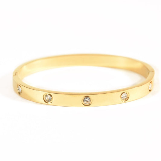 Elegant stainless steel bangle with a sleek push-lock design and polished finish, available in gold, rose gold, and silver, perfect for everyday wear, effortless stacking, and styling with watches.