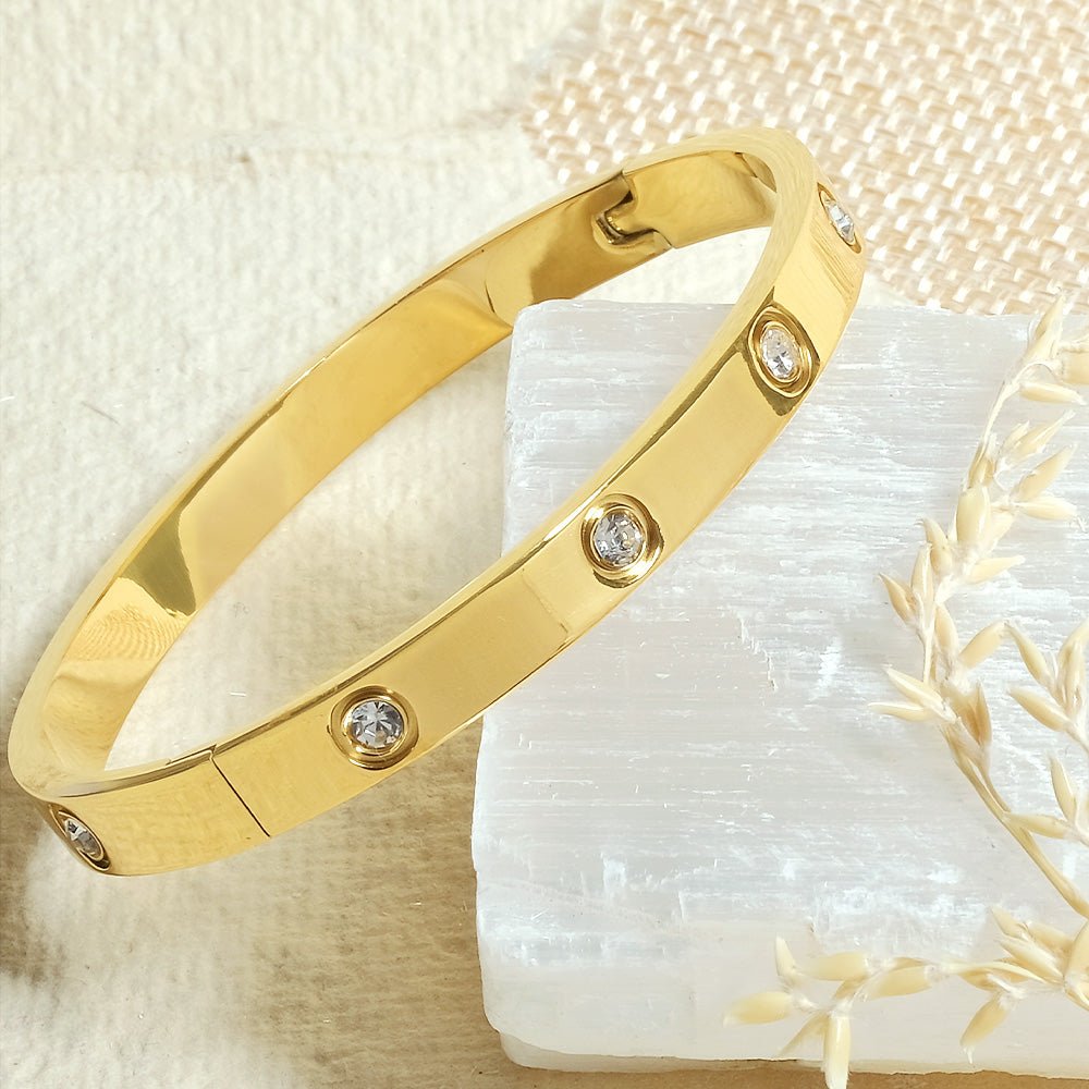 Elegant stainless steel bangle with a sleek push-lock design and polished finish, available in gold, rose gold, and silver, perfect for everyday wear, effortless stacking, and styling with watches.
