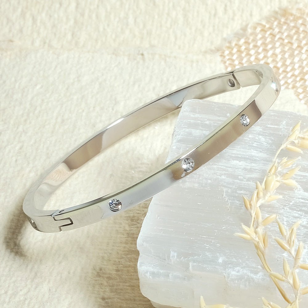 Elegant stainless steel bangle with a sleek push-lock design and polished finish, available in gold, rose gold, and silver, perfect for everyday wear, effortless stacking, and styling with watches.
