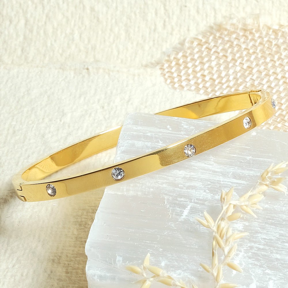 Elegant stainless steel bangle with a sleek push-lock design and polished finish, available in gold, rose gold, and silver, perfect for everyday wear, effortless stacking, and styling with watches.
